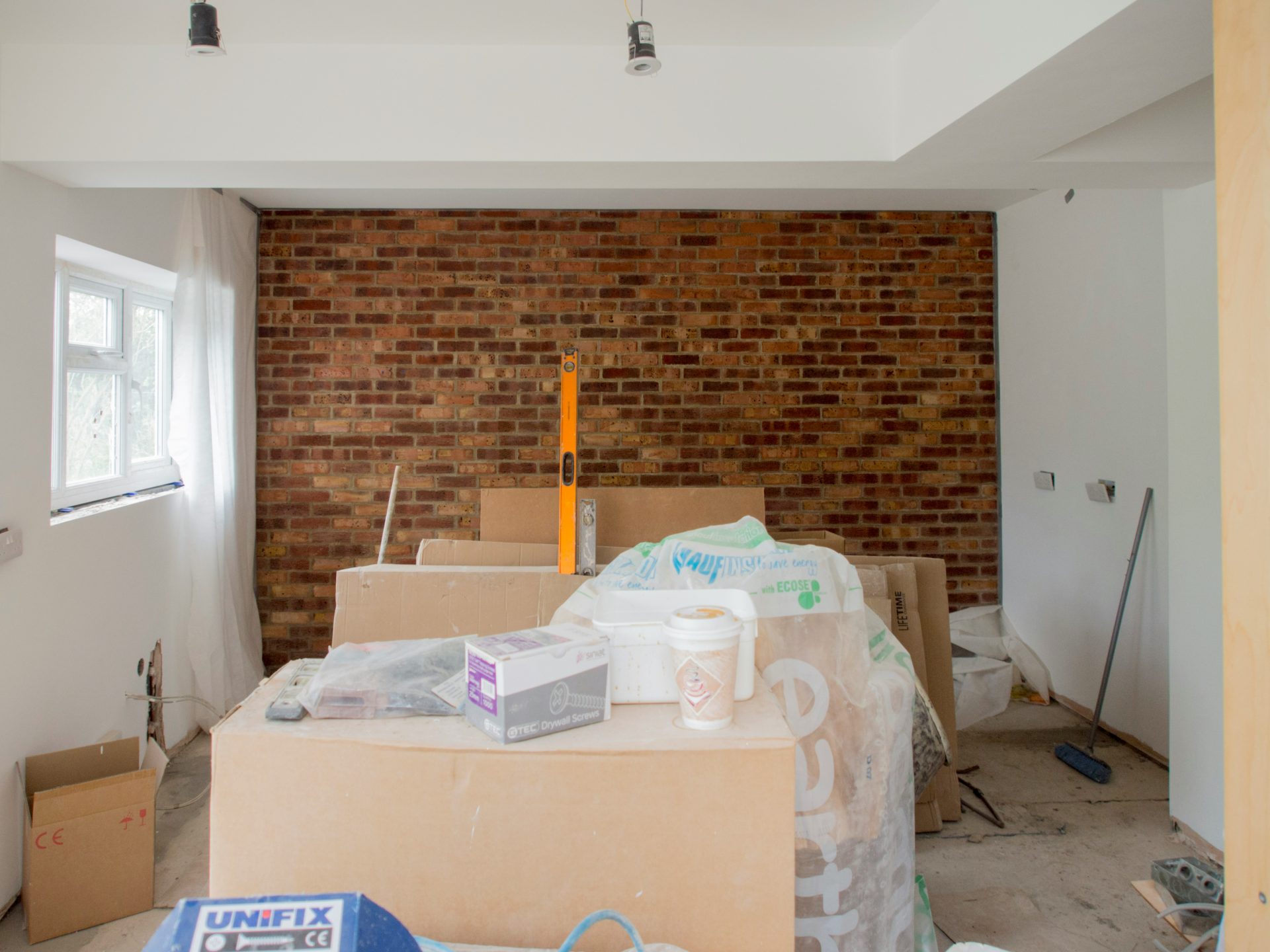 Una habitación con una pared de ladrillos y cajas en el suelo.