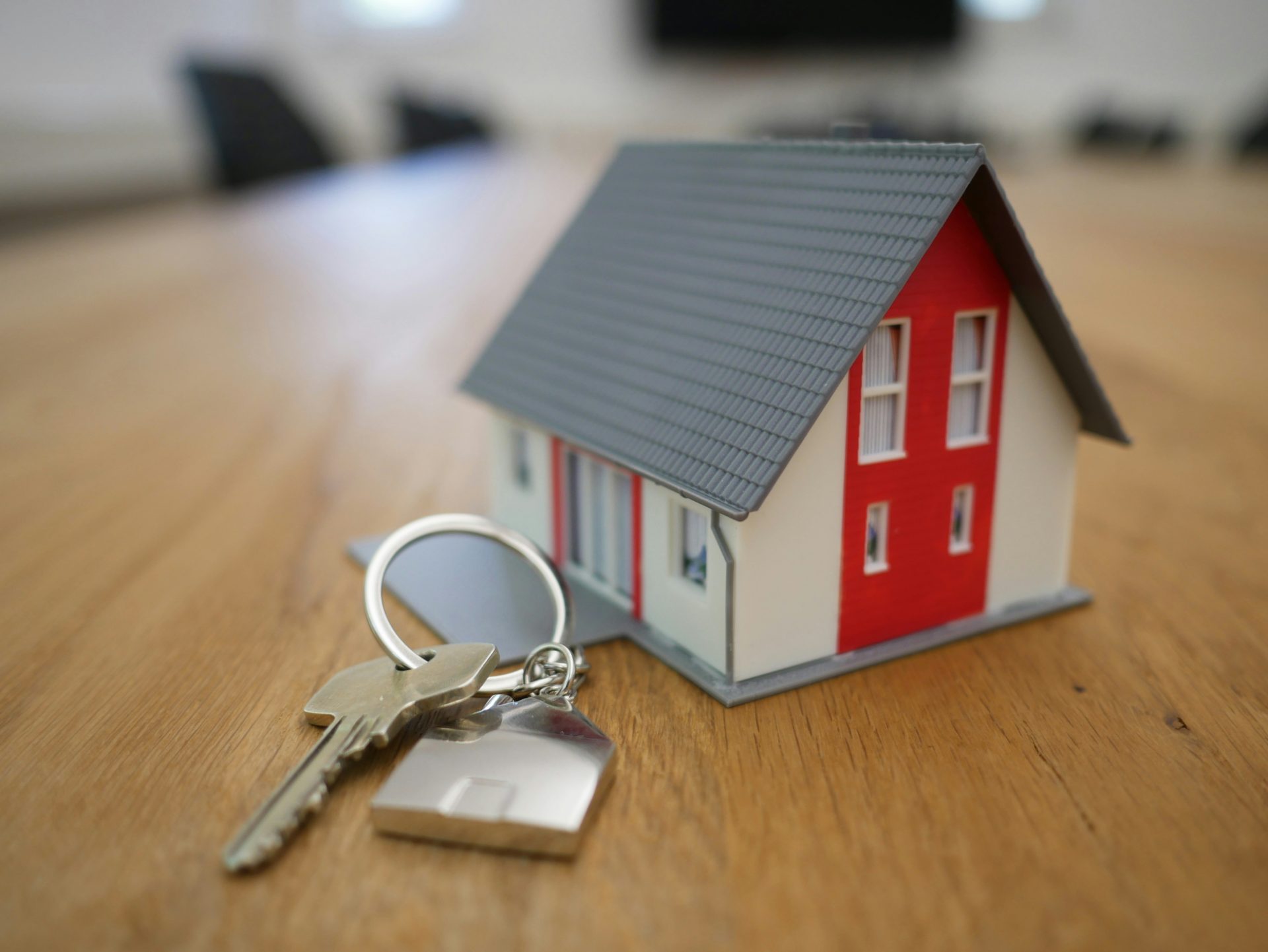 Casa de madera en miniatura blanca y roja sobre mesa marrón.